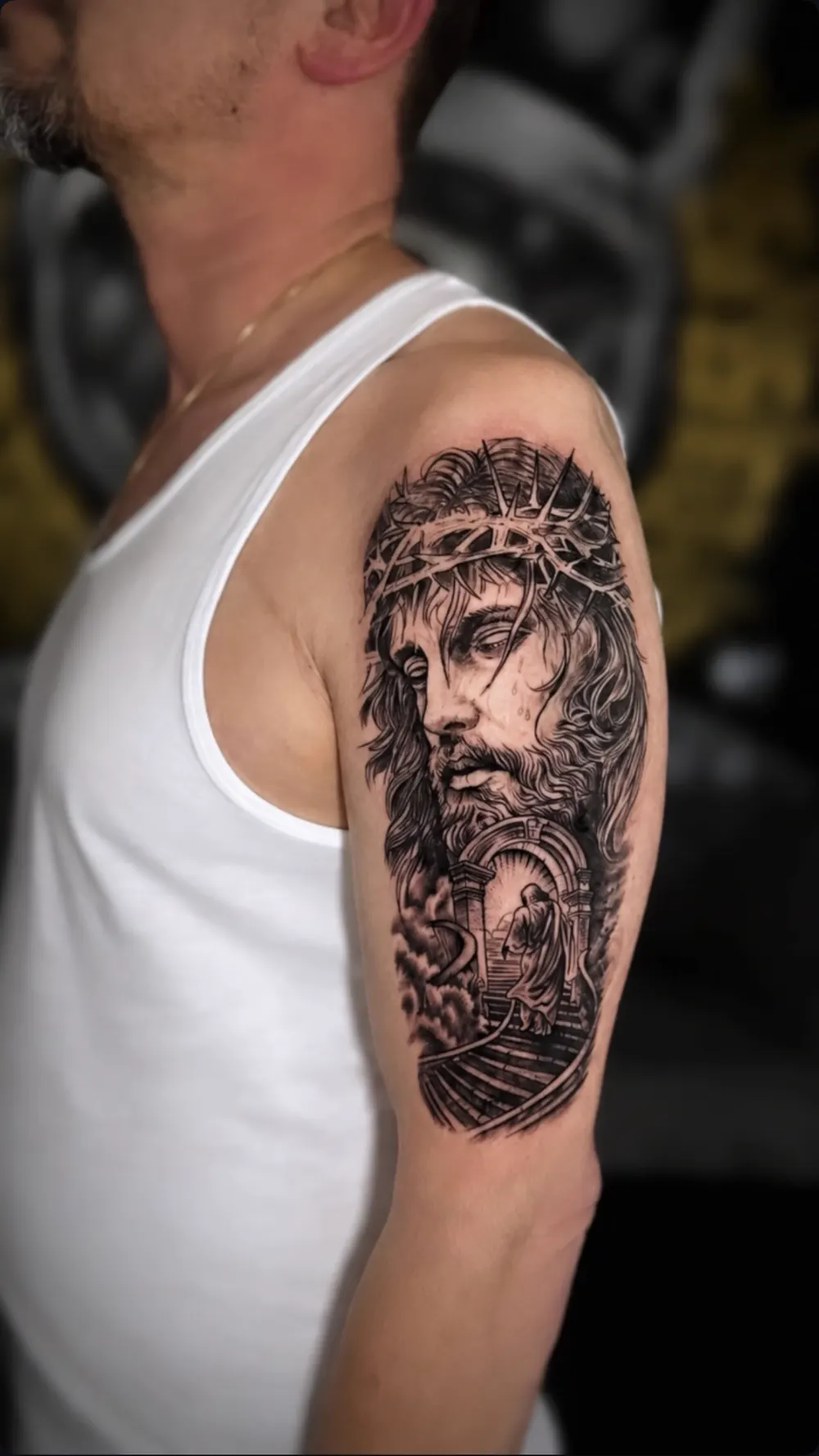 Jesus-Portrait als Black-and-Grey-Tattoo am Oberarm