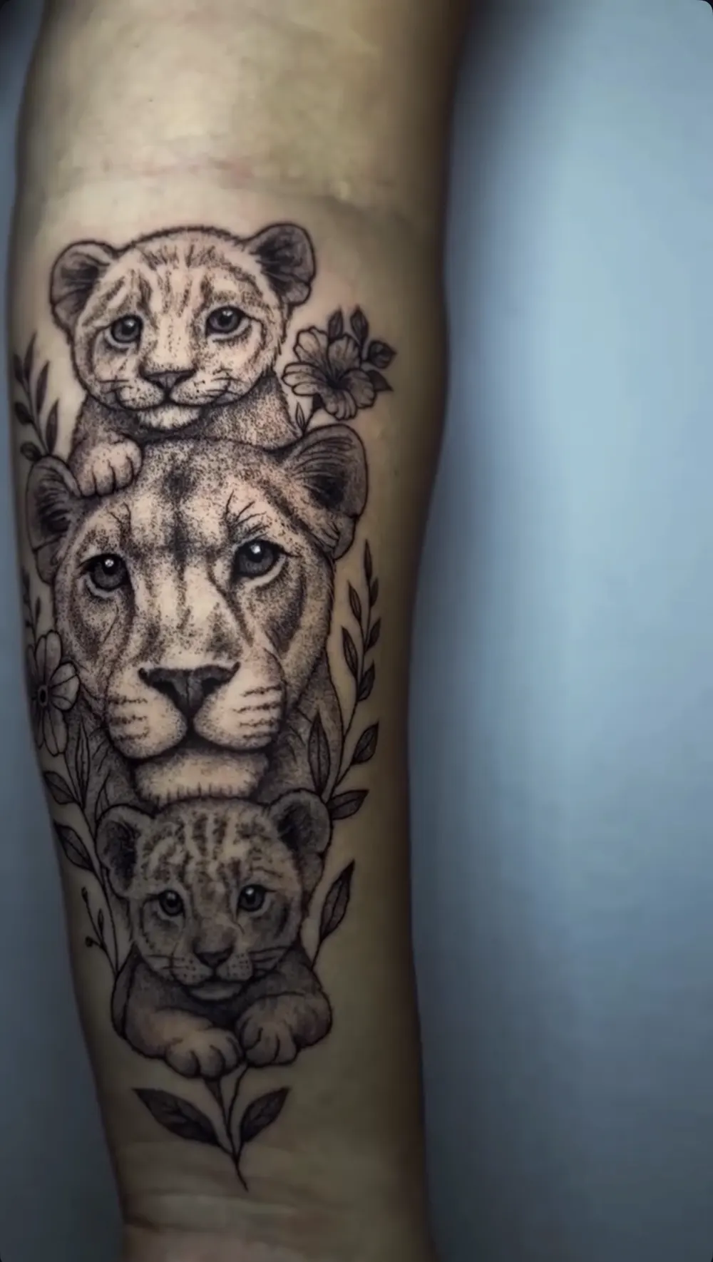 Löwenfamilie als Black-and-Grey-Tattoo am Unterarm